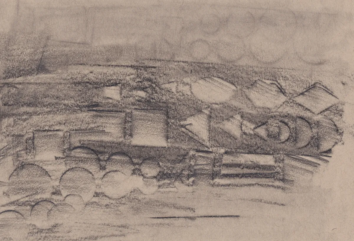 Charcoal rubbing on brown paper: a band of blocks, triangles and half-circles running across the sheet like a frieze